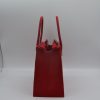 Print Luxe Handbag Vase Een levendige rode luxe handtas vaas, 3D-geprint, met een subtiel bladpatroon en een zilveren sluiting.