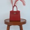 Print Luxe Handbag Vase Een levendige rode luxe handtas vaas, 3D-geprint, met een subtiel bladpatroon en een zilveren sluiting.