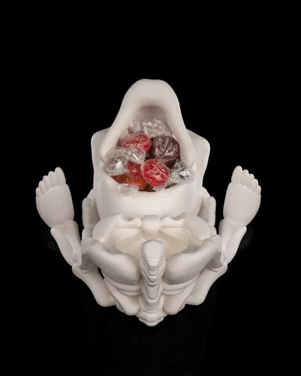Een gedetailleerde 3D-geprinte CRANI-YUM CANDY HOLDER in de vorm van een skelet dat een schedel vasthoudt. De schedel dient als snoephouder. Het witte skelet heeft zichtbare ribben en botstructuren, terwijl de uitgesneden oogkassen en mond van de schedel een griezelig, speels effect geven.